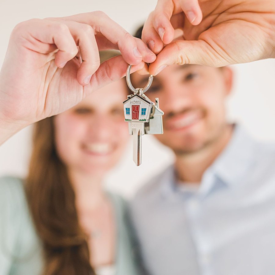 Familia sonriente con las llaves de su nueva vivienda